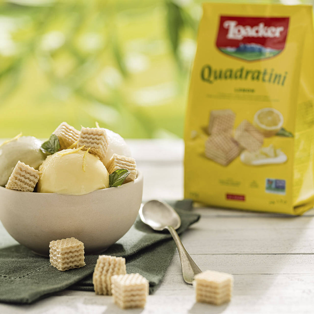 Quadratini Lemon, Crème-Filled Wafer Cookies, 8.82 oz. Bag with ice cream on a bowl and a spoon next to it.